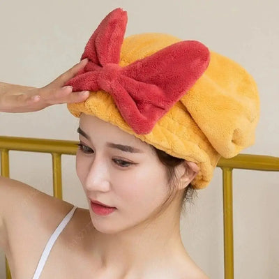 Frau trägt das HairHug Mikrofaser Haartrocknungshandtuch mit großer Schleife – schnelltrocknend, schonend und rutschfest für sanftes Haartrocknen ohne Hitze.